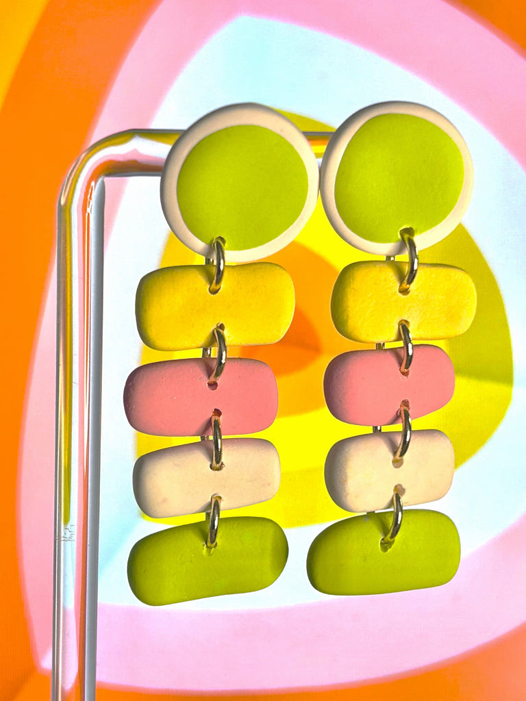 Polymer clay earrings with lime green circular tops and dangling pastel rectangles in yellow, pink, off-white, and green, connected by small metal loops