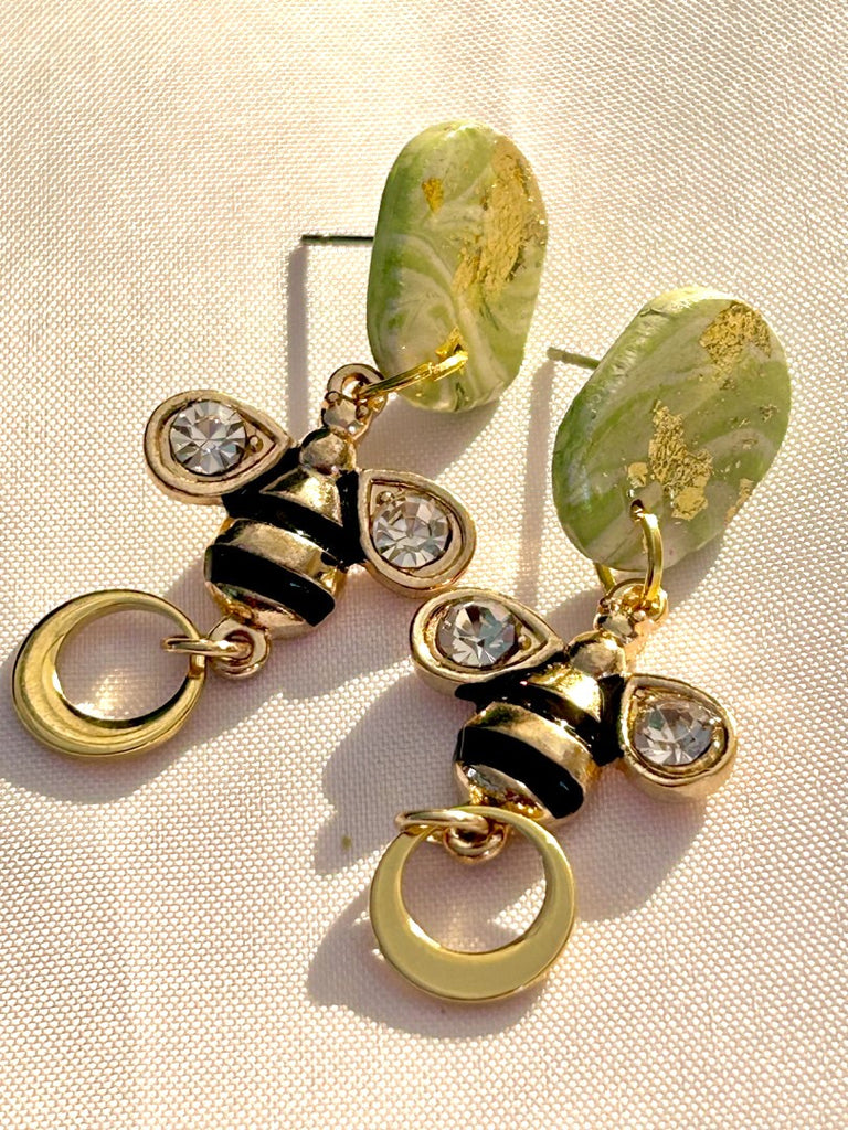 polymer clay earrings with green studs, bee charms, and gold hoop details