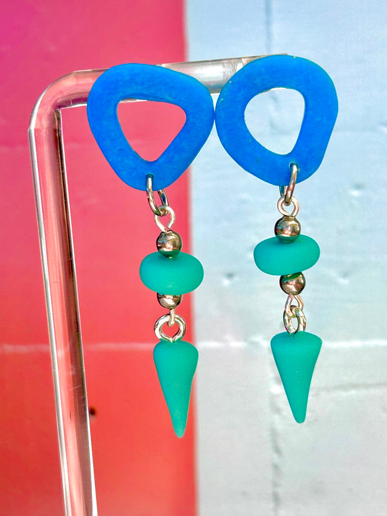 blue abstract polymer clay stud earrings with teal bead and cone-shaped dangles