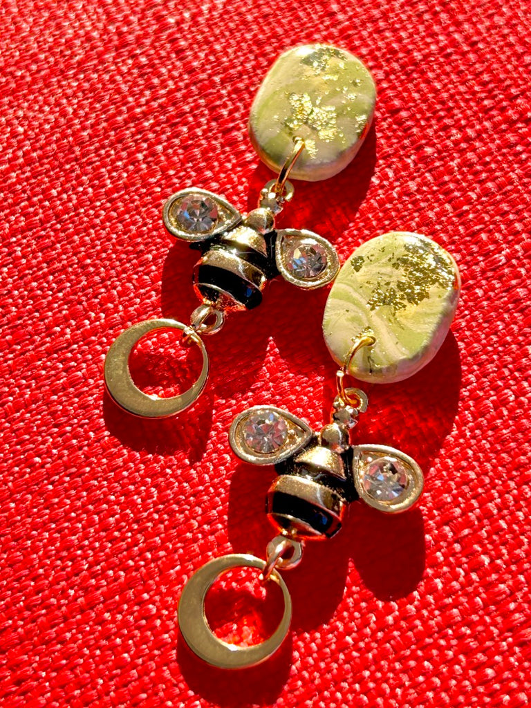 polymer clay earrings with green studs, bee charms, and gold hoop details