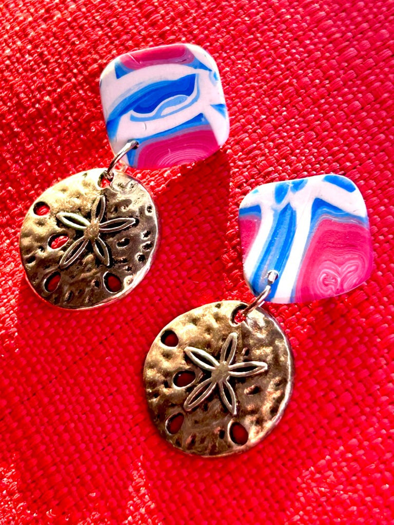 A pair of ocean-themed polymer clay earrings in red, white, and blue