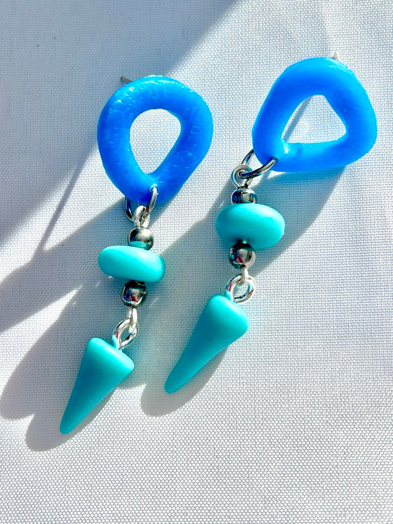 blue abstract polymer clay stud earrings with teal bead and cone-shaped dangles