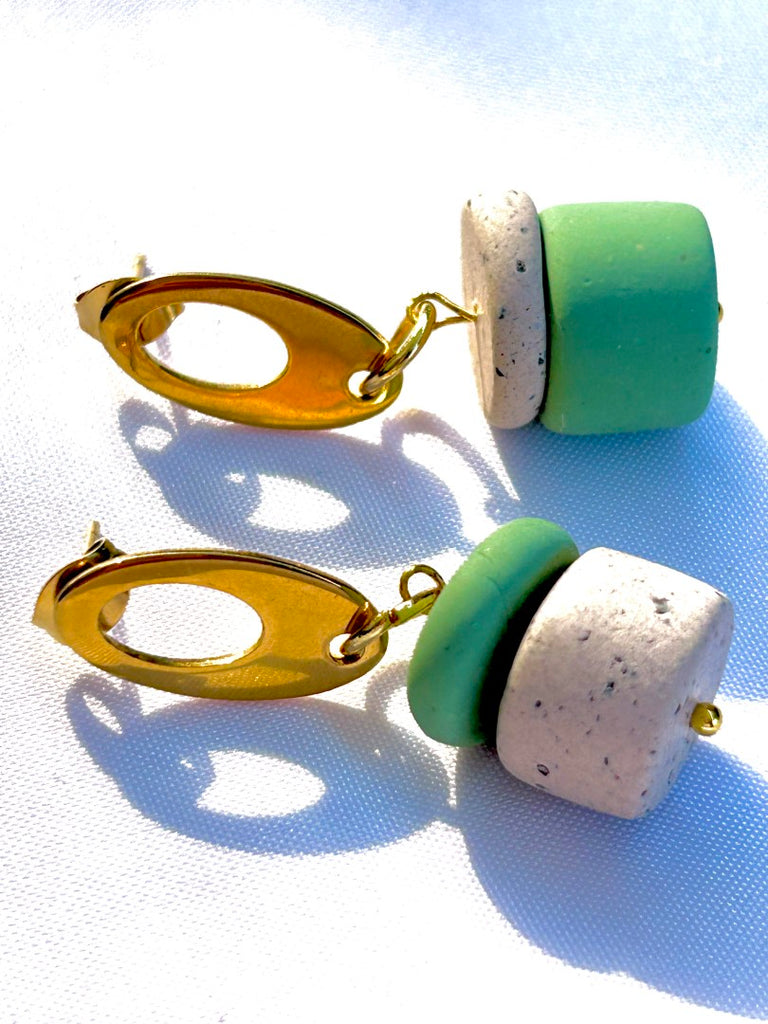 Asymmetrically stacked sage and coffee-speckled polymer clay earrings with golden oval studs